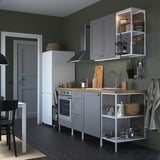 Moderne graue Küche: weißer Kühlschrank, graue Schränke, Holztheke, schwarzer Herd. Offener und geschlossener Stauraum, schwarze Fliesen, weiße Stühle.