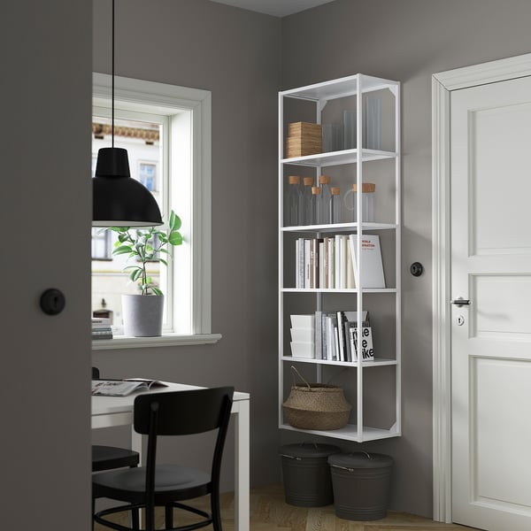 Minimalistisches Büro: ENHET Bücherregal mit Büchern, Gläsern und Korb, zwischen Schreibtisch und weißer Tür.