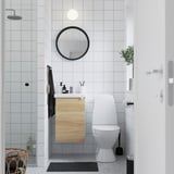 Kleines Badezimmer mit weißer Toilette, ENHET-Schrank und Glasdusche. Schwarz-weißes Dekor, sauber, modern.