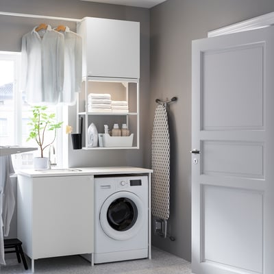 Kompakte, weiße Wäscherei. Waschmaschine, Spüle, Regale und Wäscheständer. Modernes, minimalistisches Design. Perfekt für kleine Räume.
