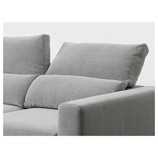 Ein modernes, bequemes Sofa mit verstellbaren Kopfstützen und Chaiselongue, bezogen mit hellgrauem Stoff.