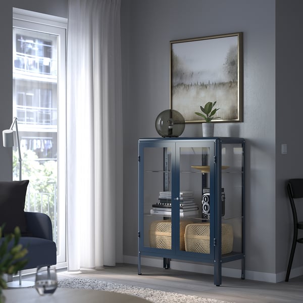 Eine FABRIKÖR-Vitrine in Blau mit Glastüren, in denen verschiedene Gegenstände ausgestellt sind.
