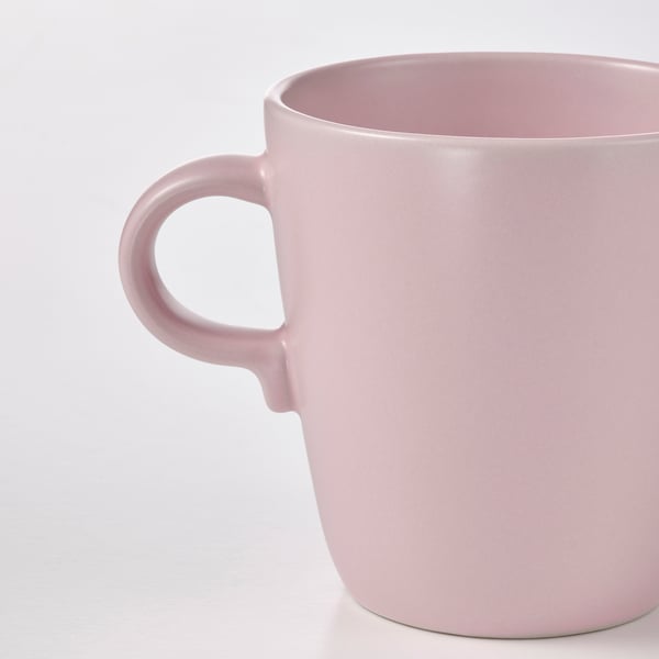 Hellrosa Becher mit glattem Henkel; Schlichtes, elegantes Design.