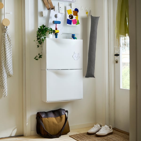 Kleiner weißer FAGEBLÅMME Kissenbezug mit grauen Krawatten an der Wand in der Nähe des Kühlschranks.