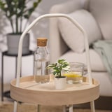 Minimalistisches, modernes Tablett mit Griff für Glas, kleine Pflanze, Tasse. Tabletts rund, helles Holz, Metallbeine.