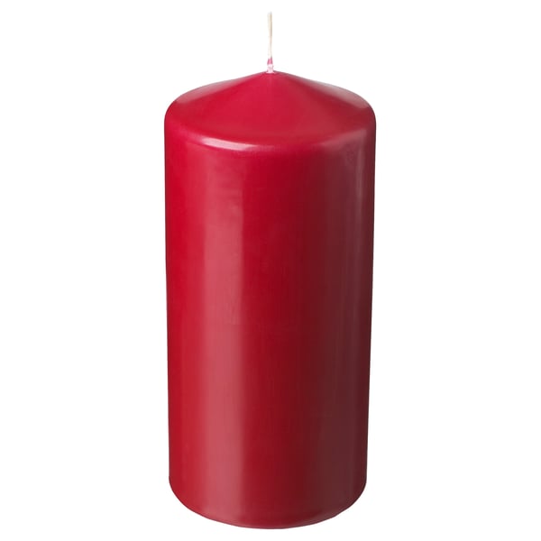 Eine einzelne, hohe rote Kerze mit zylindrischer Form aus pflanzlichem Wachs und Baumwolldocht.