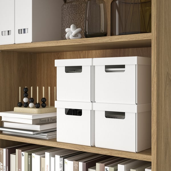 Holzregal mit weißen Aufbewahrungsboxen, Dekorationsartikeln und Büchern, perfekt zum Organisieren kleiner Gegenstände.