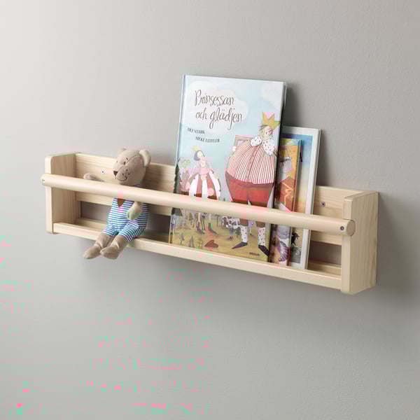In einem Wandregal aus Holz befinden sich ein Teddybär und Kinderbücher. Die offene Front ermöglicht einen einfachen Einstieg für Kinder.