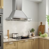 Moderne Küche mit Dunstabzugshaube aus Edelstahl, LED-Leuchten und schlankem Design.