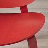 Leuchtend roter moderner Stuhl aus nächster Nähe, glatte Oberfläche und schlankes Design.