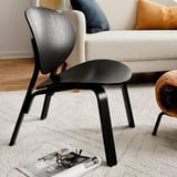 Schwarzer moderner Holzstuhl in der Nähe der weißen Couch. Stilvolles skandinavisches Design, schlanke Linien, minimalistisch.