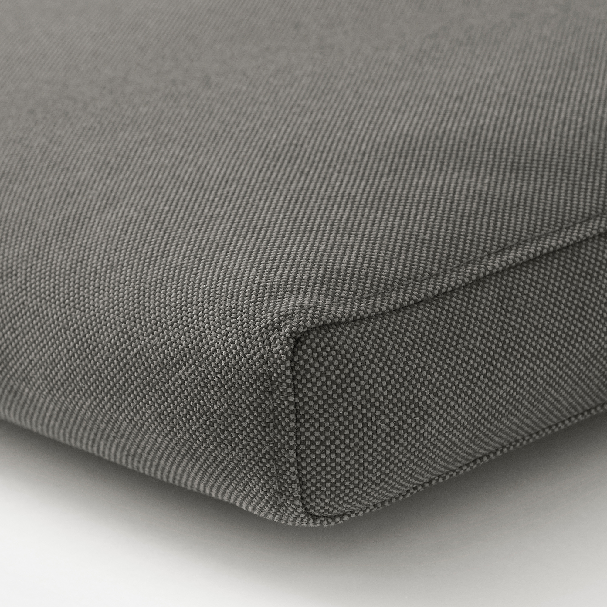 Nahaufnahme eines strapazierfähigen, strukturierten grauen Kissenbezugs mit sichtbaren Nähten und Reißverschluss, der Qualität und Design zeigt.