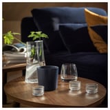 Wohnzimmer mit blauem Sofa, hölzernen Beistelltischen, Dekor und Pflanzen.