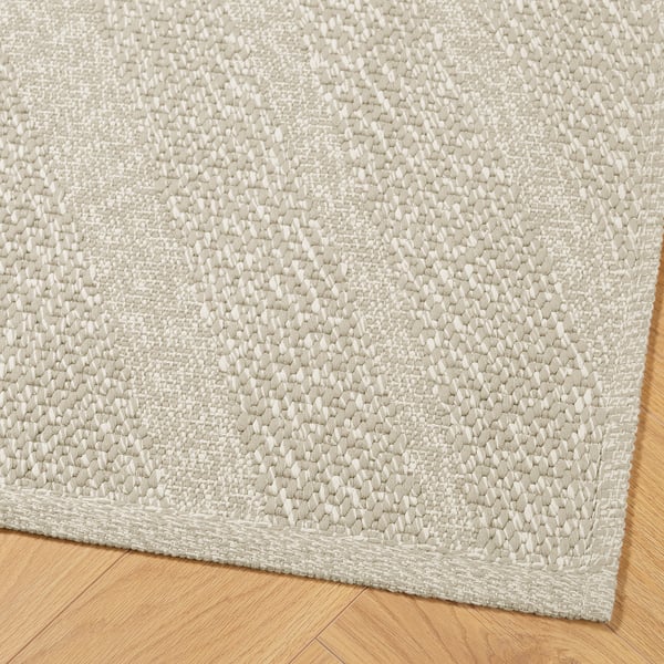Hochwertiger, beigefarbener Webteppich auf Holzboden, der eine komplizierte Textur und Handwerkskunst zeigt.
