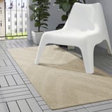 Minimalistischer weißer FULLMAKT-Stuhl auf großem beigen Teppich, ideal für den Außenbereich auf grauen Fliesen.