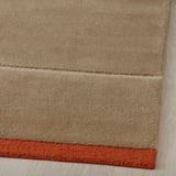 Nahaufnahme eines handgefertigten Wollteppichs, der eine weiche Textur und hochwertige Verarbeitung zeigt.