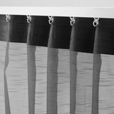 Schwarz-weiß gestreifte Vorhänge hängen mit Haken an der Spitze. Der durchsichtige Stoff lässt Licht und sorgt gleichzeitig für Privatsphäre.