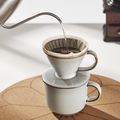 Eine übergießbare Kaffeemaschine, bei der das Wasser durch einen Keramikfilter in eine Tasse darunter abläuft.