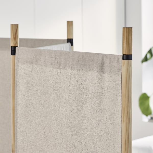 Beigefarbener Raumteiler mit Holzstangen. Da das Original bereits innerhalb der maximalen Zeichenbeschränkung liegt, ist keine Kürzung erforderlich.