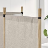 Beigefarbener Raumteiler mit Holzstangen. Da das Original bereits innerhalb der maximalen Zeichenbeschränkung liegt, ist keine Kürzung erforderlich.
