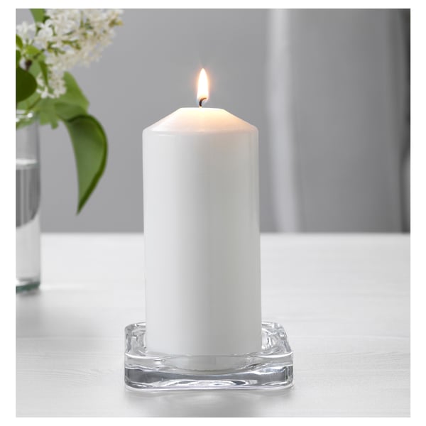 Weiße Kerze in klarer Glasschale für Ambiente.