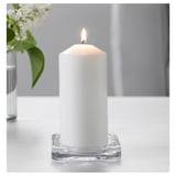 Weiße Kerze in klarer Glasschale für Ambiente.