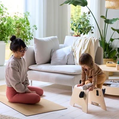 Ein Holzspielzeug, GREJSIMOJS, in Form eines Elefanten mit Filzdetails. Es ist in Beige und Schwarz gehalten und mit einfachen, kindgerechten Kurven gestaltet.