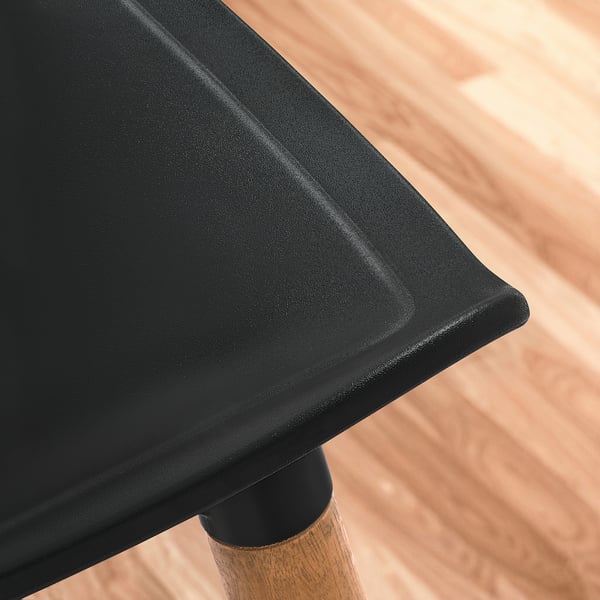 Schwarz geformter Sitz mit schlanken Kanten und geschwungenen Formen, die anspruchsvolles Design und Komfort hervorheben.