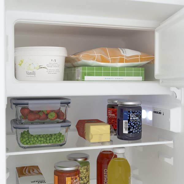 Kühlschrankregal mit verstellbaren Glasböden für Erdbeeren, Erbsen, Käse und Gläser. LED-Licht an.