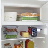Kühlschrankregal mit verstellbaren Glasböden für Erdbeeren, Erbsen, Käse und Gläser. LED-Licht an.