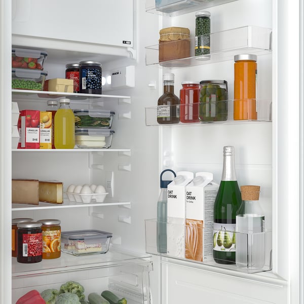 Gut organisierter Kühlschrank mit verstellbaren Regalen, in dem Obst, Gemüse, Käse, Getränke und Gewürze in einer ordentlichen Anordnung aufbewahrt werden.