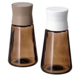 Paar braune Gewürzdosen aus Glas mit weißem und beigem Deckel, spitz zulaufende Form, trendiges Design.