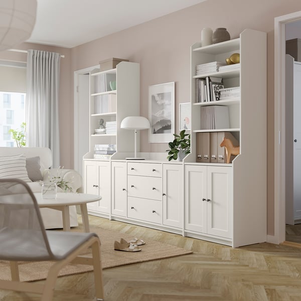 Modernes Wohnzimmer mit weißen HAUGA-Schränken, Socken, Lampe und Büchern.