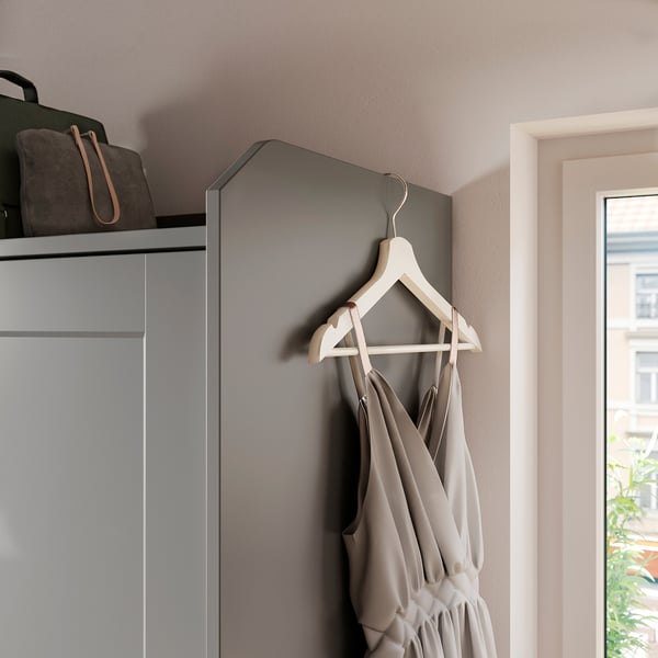Moderner Kleiderschrank mit Schiebetüren, graue Farbe, leichter Stoffkleiderbehang, Holzbügel, minimalistisches Design.