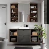 Modernes Badezimmer mit dunkelgrauem HAVBÄCK-Waschtisch, Spiegel und offenen Regalen vor einer weiß gefliesten Wand. Inklusive Spüle und Stauraum.