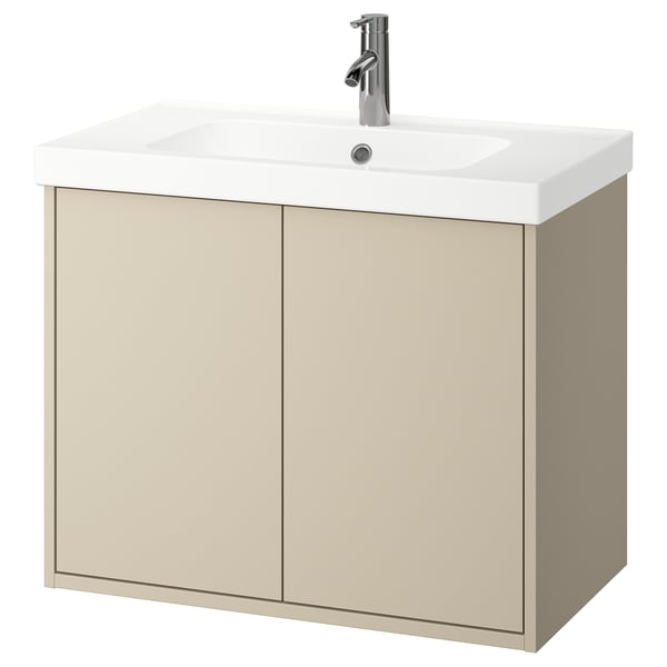 Ein wandmontierter Badezimmerschrank in hellem Beige mit einem weißen Waschbecken darauf. Der Schrank bietet Stauraum und hat ein klares, minimalistisches Design.