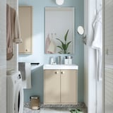 Modernes Badezimmer: blaue Fliesen, beiger HAVBÄCK-Schrank, weißes Waschbecken, hellgraue Waschmaschine, weißer Bademantel, gemusterter Teppich, minimalistisch.