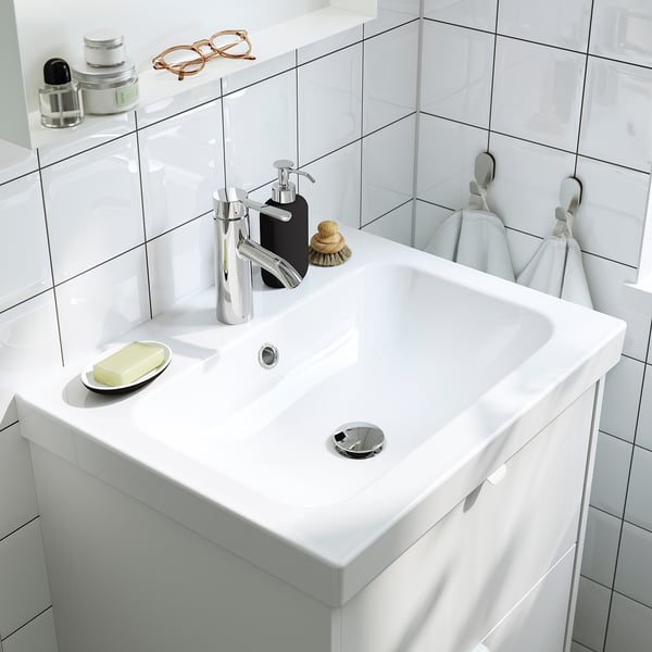 Modernes weißes Waschbecken mit Seifenspender, Handtuchhaken und klarem, minimalistischem Design. Mattgraue Griffe erhältlich.