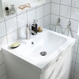Modernes weißes Waschbecken mit Seifenspender, Handtuchhaken und klarem, minimalistischem Design. Mattgraue Griffe erhältlich.