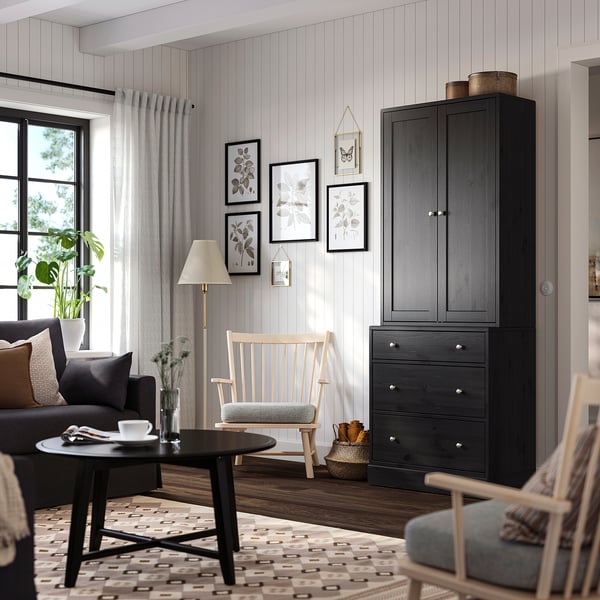 Wohnzimmer mit HAVSTA-Schrank, Kunst, Stuhl, Vorhängen, Teppich.