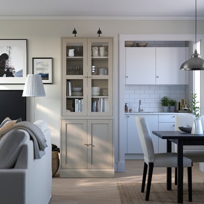 Modernes Wohnzimmer mit grauem HAVSTA-Regal, weißen Möbeln, Esszimmergarnitur, Pflanzen und Wandkunst.