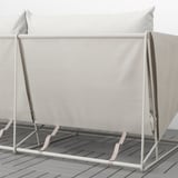 Modernes Outdoor-Sofa mit hellgrauen Kissen und Metallrahmen auf Holzdeck.