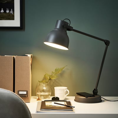 Moderne schwarze HEKTAR Schreibtischlampe mit warmem Licht, schlankem, verstellbarem Design, großem Schirm, zwischen Büchern, Bechern und Pflanzen.