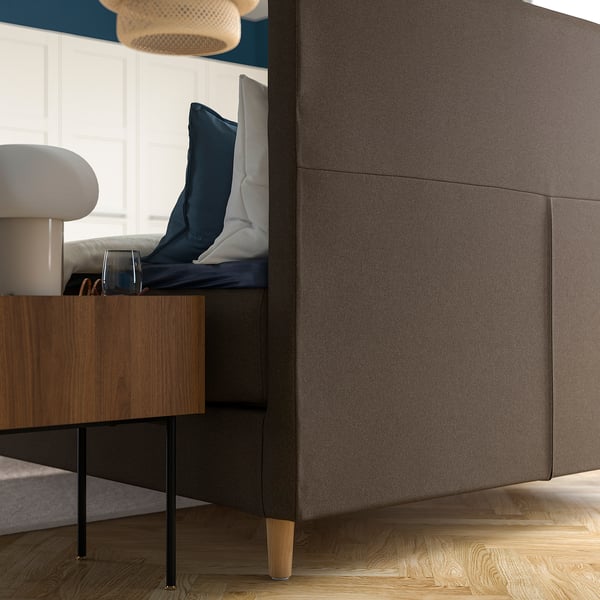 Modernes Bett mit weichem, stützendem Kopfteil, Holzbeinen und abnehmbaren, waschbaren Bezügen.