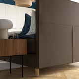 Modernes Schlafzimmer mit HEMFJÄLLET-Schlafcouch, weichem Kopfteil zum Lesen, Holzbeinen und gemütlichen Kissen.