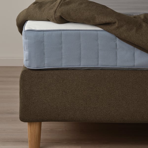 Ein modernes Bett mit einem weichen, stützenden Kopfteil mit abnehmbaren, maschinenwaschbaren Bezügen für eine einfache Reinigung.