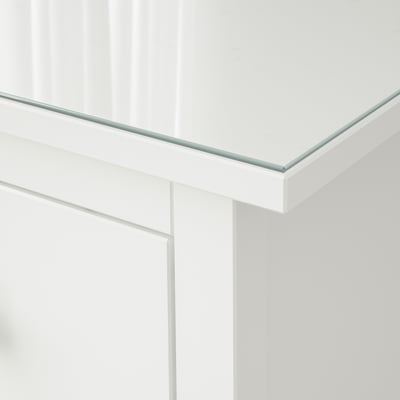 Klare, gehärtete Glasoberfläche, nahtlos auf einem weißen Schrank montiert, reflektiert das Licht.