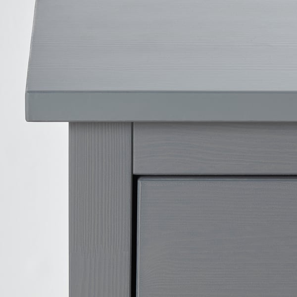 Graue Holztruhe mit glatter, ebenmäßiger Oberfläche und sauberen Kanten. Hochwertige Handwerkskunst, sichtbar in der detaillierten Holzmaserung.