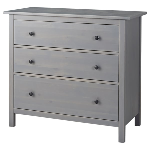 Dabei handelt es sich um eine graue HEMNES-Kommode aus massivem Kiefernholz und Faserplatten mit drei glatten Schubladen und klassischem Design.