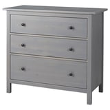 Dabei handelt es sich um eine graue HEMNES-Kommode aus massivem Kiefernholz und Faserplatten mit drei glatten Schubladen und klassischem Design.